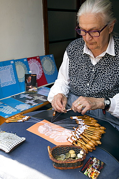 Old lady making lace by hand using pins and bobbins, Bruges, West Flanders, Belgium, Europe