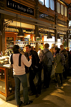 Spanish enjoy tapas and wine in indoor market, Mercado de San Miquel, Madrid, Spain, Europe