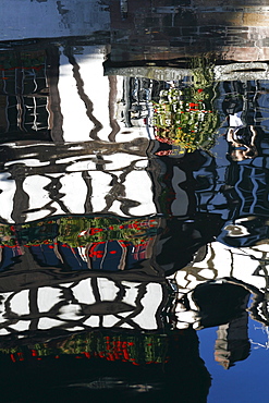 Half-timbered building reflected in canal, Strasbourg, Alsace, France, Europe