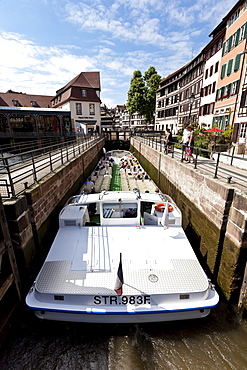 Tourist boat travelling through a lock on the Ill River, Petite France, Strasbourg, Alsace, France, Europe