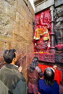 Pilgrims in front of a red-coloured stone statue in Kamakhya Temple, a Hindu temple, Guwahati, Assam, North East India, India, Asia