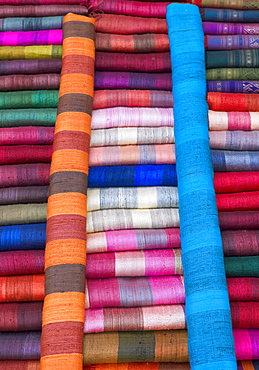 Colourful silk textiles on display at a market stall in Luang Prabang, Laos, Southeast Asia