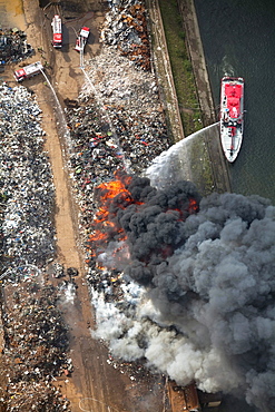 Aerial view, smoke, fire on a scrap island in the Duisport inland port, Duisburg, Ruhrgebiet region, North Rhine-Westphalia, Germany, Europe