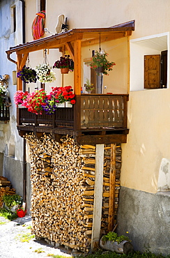 Firewood stored underneath a balcony, historic mountain village, Ardez, Engadin valley, Switzerland, Europe