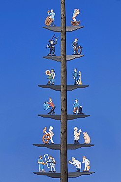 Group of figures on a May pole, scenes of craftspeople