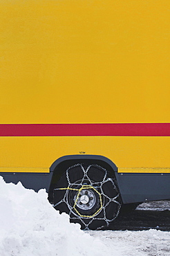 Van with mounted snow chains on a wintry road