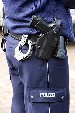 Police, police officer with handcuffs and service weapon, Walther P99, in the holster