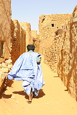 Man walking through the sandy lanes of the town of Chinguetti, Mauritania, northwestern Africa