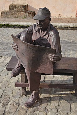 Old man reading a newspaper, sculpture, Plaza del Carmen, historic district of Camagueey, Cuba, Caribbean, Central America