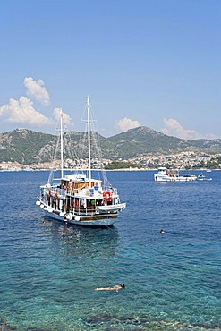 Excursion boats anchoring off Stipanska Island, Hvar Island at back, Central Dalmatia, Adriatic Coast, Croatia, Europe