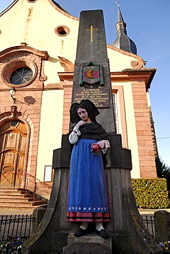 Second World War memorial with statue of woman wearing traditional Alsatian costume in front of a church, Ingersheim, Alsace, France, Europe