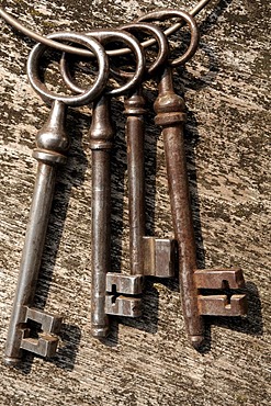 Old barn door keys on a wooden board