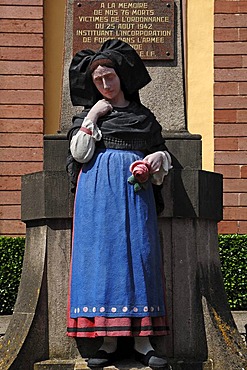 World War 2 War Memorial with a statue of a woman wearing the Alsatian traditional costume in front of a church, Rue de Jeanne d'Arc, Ingersheim, Alsace, France, Europe