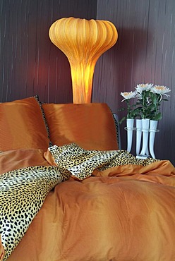 Luxurious bed in an exclusive design with a stylish lamp