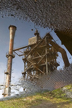 Blast furnace reflected in a puddle, Landschaftspark Duisburg Nord landscape park, Ruhrgebiet area, North Rhine-Westphalia, Germany, Europe