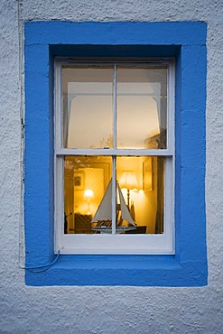 Illuminated window with miniature sailboat, Scotland, United Kingdom, Europe