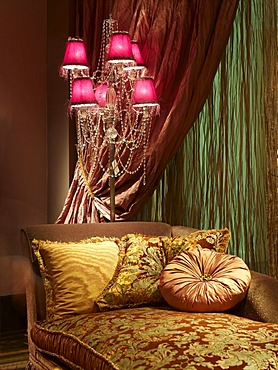 Baroque canape in luxurious surroundings with atmospheric lighting and draped curtain fabrics