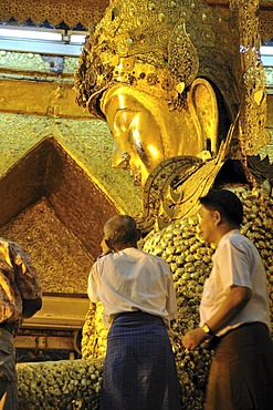 Believers sticking gold foil on a Buddha statue, Mahamuni Pagoda, Mandalay, Burma, Myanmar, Southeast Asia