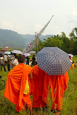 Festival, launching of a Bang Fai rocket, being watched by monks dressed in orange robes, Muang Xai, Oudomxai province, Laos, Southeast Asia, Asia