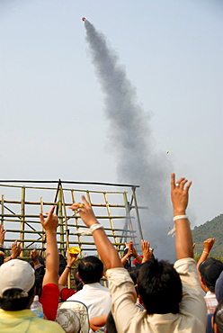 Rocket rising in the sky shortly after launch from a launch pad, cheering spectators, Pi Mai, Lao New Year festival, city of Phongsali, Phongsali province, Laos, Southeast Asia, Asia