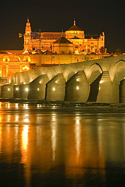 The artificially illuminated Puente Romano crossing the Guadalquivir river with the Mezquita at back, Cordoba, Andalusia, Spain, Europe