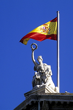 National flag and statue at the National Library, Biblioteca Nacional, also a museum, Museo del Libro, Paseo de Recoletos, Madrid, Spain, Europe