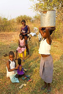 Girl carrying a water jug on her head, African village Sambona, Southern Province, Republic of Zambia, Africa