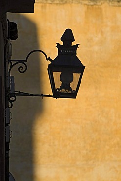 Silhouette of a street lamp in front of a yellow wall in Cordoba, Andalusia, Spain, Europe