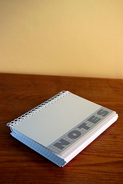 Closed ringed notebook, notebook on a wooden desk