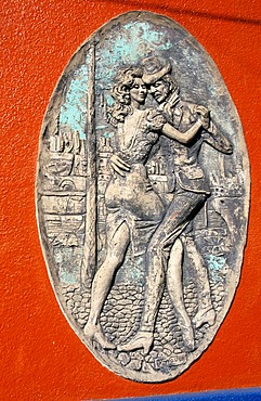 Relief of of two Tango dancers on a wall of the tourist alley Caminito in the dockland area La Boca, Buenos Aires, Argentina, South America