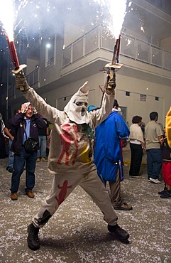 During the Correfoc or Fire Run, hooded Fire Devils run the streets of Spanish towns brandishing fireworks, Altea, Costa Blanca, Spain