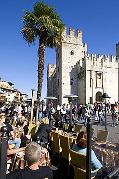 Tourists sitting in a cafe in front of the Scaligero Castle, Sirmione, Lake Garda, Lago di Garda, Lombardy, Italy, Europe