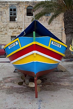 Traditional Maltese fishing boat, called Luzzu, standing ashore for maintenance, port of Marsaxlokk, Malta, Europe