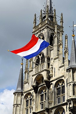 Gothic guildhall, stadhuis, on the marketplace of Gouda. The ensign indicates a nationwide celebration or commemoration day. Gouda, South-Holland, Zuid-Holland, Nederland, The Netherlands