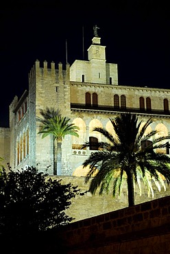 Illuminated Almudaina Palace in the evening, Palau de Almudaina, historic castle with palm trees in the historic centre, Ciutat Antiga, Palma de Majorca, Balearic Islands, Spain, Europe