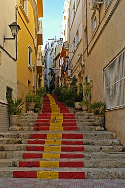 Steep lane with stairway steps in the Spanish national colors, old part of town of Calpe, Costa Blanca, Spain