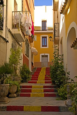 Steep lane with stairway steps in the Spanish national colors, old part of town of Calpe, Costa Blanca, Spain