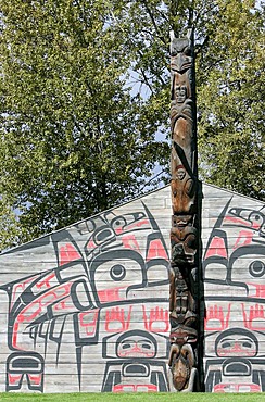 Totem pole and Indian drawings in front of a long house at Ksan Historical Village, British Columbia, Canada