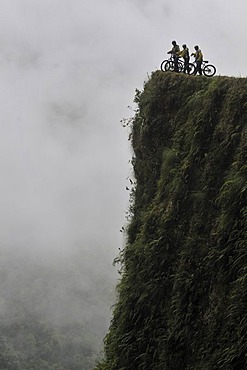 Mountainbikers at the edge of a dangerous cliff, Deathroad, Yungas, La Paz, Bolivia, South America