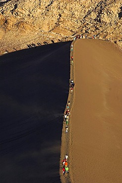 People on a sand dune in the Moon Valley (Valle de la luna), Atacama desert, northern Chile, South America