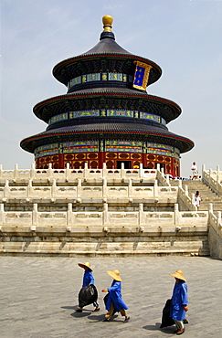 Three female sanitation workers walking past the Hall of Prayer for Good Harvest, Temple of Heaven, Beijing, China