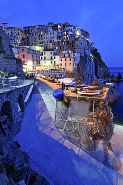 Village of Manarola nestled atop steep coastline at dusk, Liguria, Cinque Terre, Italy, Europe