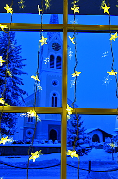 Christmas decoration, at the back the parish church Maria Opferung in Riezlern, Kleinwalsertal, Austria, Europe