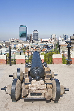 Old canon aimed in the direction of Cerro Santa Lucia Park and modern high-rises, Santiago de Chile, Chile, South America