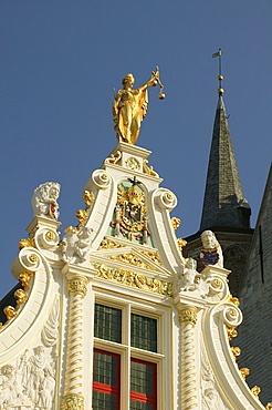 Statue of Justice with scales and sword on the gable of the courthouse in Bruges, Flanders, Belgium, Europe