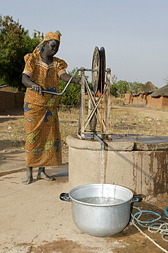 Woman getting water from a wheeled well, Pakete, Cameroon, Africa