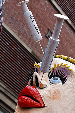 Paper-mache woman with collagen and botox needles sticking in her lips and face, Carnival (Mardi Gras) parade in Duesseldorf, North Rhine-Westphalia, Germany, Europe