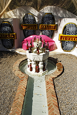 Lip sofa, Pirelli advertising banner and liquor bottle fountain in the garden at the former home of surrealist painter Salvador Dali and his wife Gala in Port Lligat, Province Girona, Spain