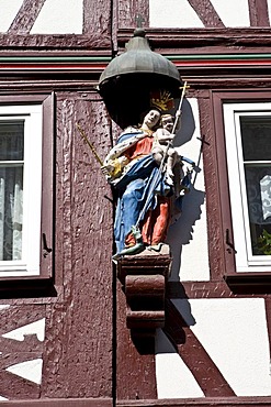 Old part of town, well-maintained timbered houses with carved figure, Miltenberg, Bavaria, Germany