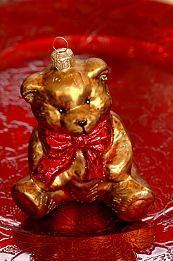 Bear with red bow, Christmas ornament sitting on red plate